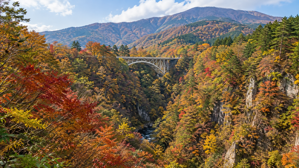 Naruko Gorge covered in brilliant autumn foliage with a bridge in the distance